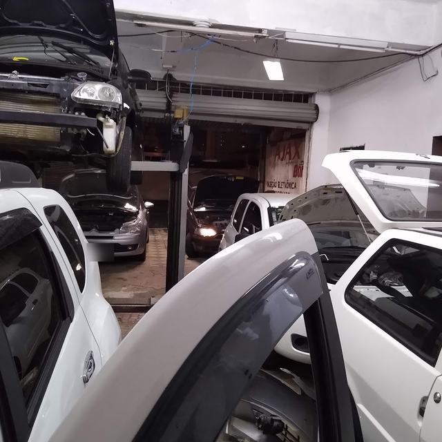 Carros com capô aberto dentro da oficina