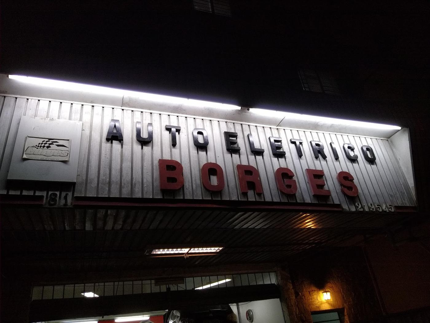 Letreiro iluminado do Auto Elétrico Borges à noite