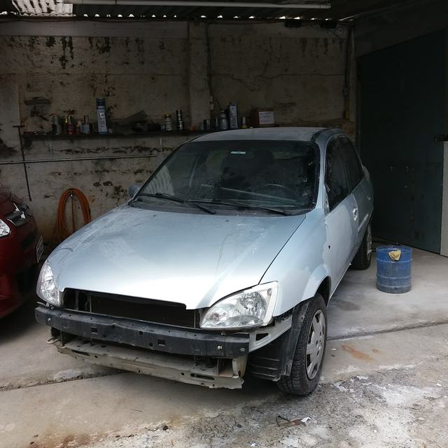 Chevrolet Corsa prata no pátio da oficina